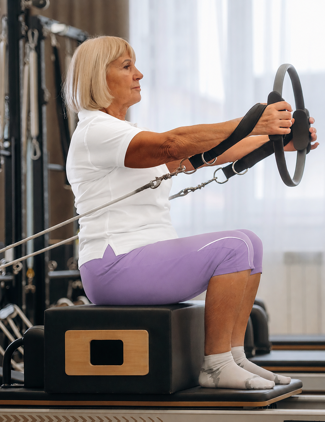 Mulher idosa praticando Pilates com círculo de resistência